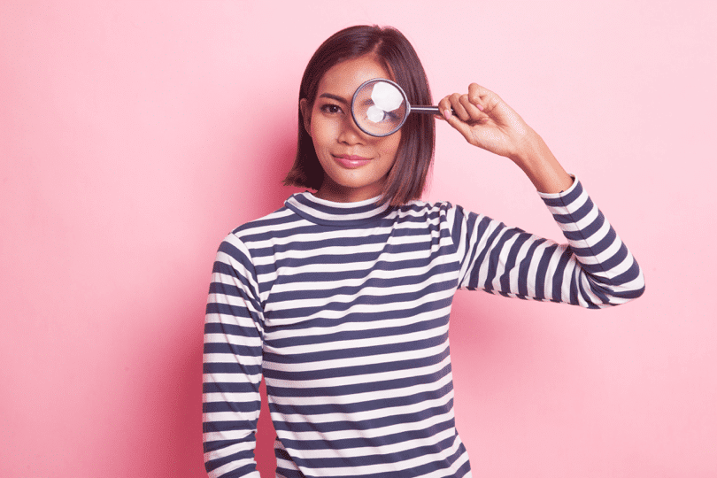 woman looking through a magnifying glass
